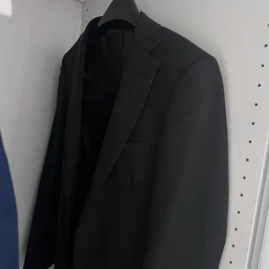 Blå kavaj från Dressmann.   1000kr för båda  - Säljer en stilren blå kavaj från Dressmann med glansigt blått innerfoderd. Klassisk passform med två knappar framtill och fickor. Perfekt för dig som vill ha en snygg och enkel kavaj till speciella tillfällen.