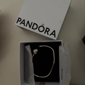 Silverarmband från Pandora  - Säljer ett stilrent silverarmband från Pandora. Armbandet har klassisk design och levereras i originalask. Perfekt accessoar för att lyfta din look. Berlocker finns att köpa och ha till