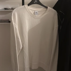 Zara Tröja - Säljer en vit tröja från Zara som är i jätte bra skick, enkel att matcha och väldigt unik. Priset kan diskuteras!