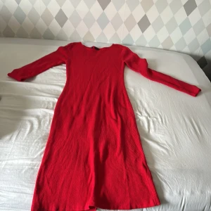 Röd långärmad klänning Bodyflirt som har används 1 gång på en julavslutning i 6an - Röd ribbad klänning från Bodyflirt med lång ärm och rund halsringning. Modellen är figurnära och har en enkel, stilren design som passar perfekt när du vill sticka ut med färg. Klänningen är i mjukt material och har en klassisk look.