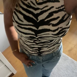 Zebramönstrad body från H&M - Säljer en snygg zebramönstrad topp från H&M i storlek S. Aldrig använd endast testad!