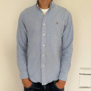 Ralph Lauren skjorta  - Riktigt fin Ralph Lauren skjorta i färgen ljusblå. Storlek S och modellen på bilden är cirka 183 cm. Slim fit Oxford. Nypris cirka 1799 kr. 