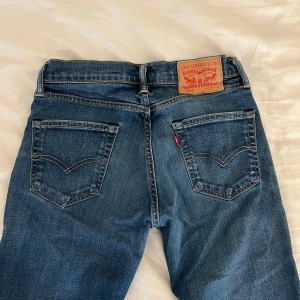 Levi's 511 blå jeans W29 L32 - Säljer ett par klassiska Levi's 511 jeans i blå denim. Modellen är slim fit med raka ben och normal midja. Jeansen har fem fickor, snygga kontrastsömmar och den ikoniska läderpatchen bak. Perfekta för en clean och tidlös look.