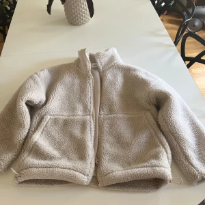 Beige teddyjacka med dragkedja - Mysig beige teddyjacka från Carin Wester med hög krage och hel dragkedja framtill. Superfin, den är använd men inga defekter som syns bortsett från armsluten där det har blivit nopprigt. Nypris:1000kr🩷
