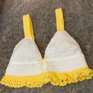 Handvirkad vit och gul linnetopp - Superfin handvirkad linnetopp i vitt och gult med breda axelband, med volangkant nertill. Toppen har en liten rosett framtill. Unik och färgglad, perfekt till sommaren☀️passar xs-s