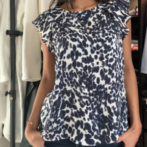 blus i  leopardmönster med volangdetaljer vid axlarna. Perfekt för en tren - Snygg blus i  leopardmönster med volangdetaljer vid axlarna. Perfekt för en trendig look.