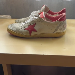 Golden Goose Ball Star sneakers vit/röd - Golden goose ball star skor i storlek 40. Skicket är ganska dåligt, men inga hål eller liknande bara använda. Finns äktahetsbevis. Skriv. Vid frågor eller liknande!