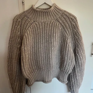 Beige chunky stickad tröja - Chunky stickad tröja i beige med hög ribbad krage. I något croppad modell och grovstickat material, perfekt för lager-på-lager och chill höst- och vinteroutfits💫