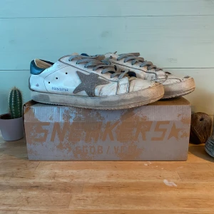 Golden Goose Skor - Storlek 43 - Säljer dessa äkta Golden Goose sneakers i storlek 43. Skorna är i den mest populäraste coluorwayen och modellen och är därför väldigt eftertraktad. Sulan är bytt hos skomakare för 750kr så att den kommer hålla länge till. Skorna är i väldigt bra skick utan större defekter. Finns frågor är det bara att höra av sig!