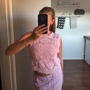 Rosa stickad ärmlös topp - Säljer denna söta stickade topp/väst. Snyggt stickat mönster och har ribbade kanter. Perfekt för lager-på-lager eller sommarens varma dagar. Är i den perfekta rosa färgen och i fint skick
