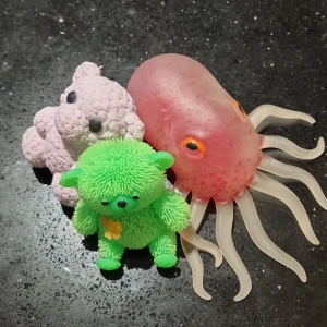 En Squishy Bläckfisk + Två björnar - En Squishy Bläckfisk med Röda Orbeez och två Mysiga Björnar. Björnarna kan man klämma på, men en stor skillnad mellan dem är att den gröna lyser i blå och röd färg om man slår den mot handen!! Bläckfisken är i bra skick, men några små märken är synliga som bl.a vid ögonen.