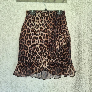 Leopardmönstrad volangkjol från NLY Trend – S - En superfin kjol från NLY Trend i leopardmönster som framhäver figuren vackert över höfter och rumpa. Nästintill nyskick endast använd en gång då den var för liten för mig.  Nypris 299kr. Kjolen har dubbla tyger: ett yttre meshliknande tyg och ett inre mjukt, svalt foder (se näst sista bilden). Volangdetaljer över framsidan och nedtill vilket hjälper till att framhäva formen.  Storlek S men något liten i storleken men passar både XS och S tack vare stretchig midja. Skickar snabbt!💕