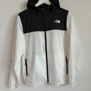 Svartvit vindjacka från The North Face - Snygg svartvit vindjacka från The North Face. Pris kan diskuteras, hör av dig vid minsta fråga!