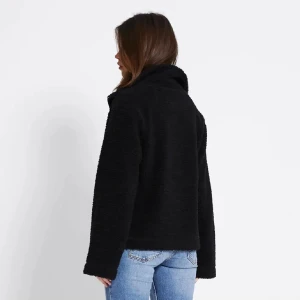 Svart teddyjacka med dragkedja - Mysig svart teddyjacka med dragkedja framtill. Jackan har en avslappnad passform och är perfekt för kyliga dagar. Den fluffiga ytan ger en cool och trendig look som passar till jeans eller leggings.