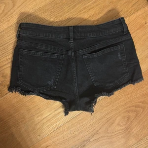 Svarta jeansshorts - Snygga svarta jeansshorts från hm i storlek 36/S med låg midja. Köpta för två år sedan så tror inte de säljs längre.