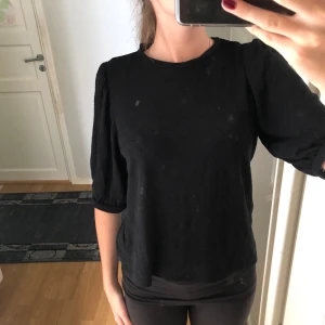 Svart blus med puffärm - Säljer en svart blus med rund hals och puffärmar som slutar vid armbågen. 
