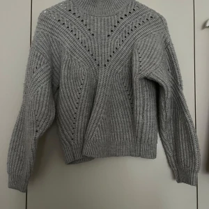 Grå stickad polotröja med mönster - Bild 1: Mysig grå stickad polotröja med snyggt mönster – perfekt både till vardags och att klä upp! Bild 2: Trendig grå kappa i oversize-modell, storlek XS men sitter som S/M enkel att matcha.                           Bild 3: Svart kappa från Lager, storlek L men är mer åt det tajta hållet – passar bäst S/M. Klassisk modell som aldrig går ur tiden.