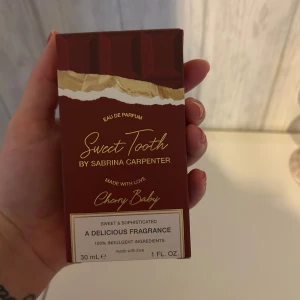 Sweet Tooth Cherry Baby parfym 30ml - Säljer en parfym Sweet Tooth Cherry Baby by Sabrina Carpenter. Förpackningen är vinröd med chokladkake-design och gulddetaljer. Innehåller 30 ml Eau de Parfum och beskrivs som söt och sofistikerad med inslag av körsbär. Perfekt för dig som gillar gourmanddofter.