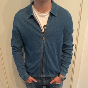 Blå overshirt från Morris, storlek M - Snygg blå overshirt från Morris i storlek M. Jackan har dragkedja framtill, klassisk krage. Perfekt att slänga på sig över en t-shirt för en avslappnad men stilren look.