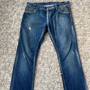 Blå jeans Jack & Jones 34/32 - Snygga blå jeans från Jack & Jones i klassisk modell med raka ben och slitna detaljer. Jeansen har fem fickor, kontrastsömmar och är tillverkade i 100% bomull. Perfekta för en avslappnad och cool stil.