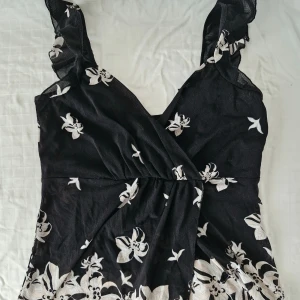 2000s wrap top med blommor - Söt wrap top med blommor 💕  Köpt här på Vinted och sparsamt använd sedan dess, i mycket fint skick! Finns ingen lapp med märke eller storlek, men den passar mig som bär S-M.  Hör gärna av er vid frågor och glöm inte att kolla in garderoben för fler liknande plagg, bundlerabatt finns! 💕