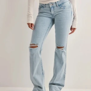 Ljusblå bootcut jeans med slitningar - Superfina och trendiga ljusblå jeans från Nelly. I storlek 36❤️ Har lite slitningar längst ner men annars är dom i fint skick! Nypris 699kr