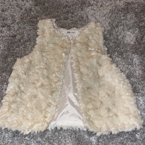 Beige pälsväst från H&M - Superfin pälsväst från H&M i storlek 140 men passar mig som brukar ha xs. Väldigt bra skick men ganska gammal