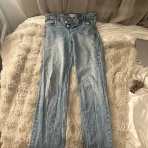 Ljusblå raka jeans från Zara - Säljer ett par ljusblå jeans från Zara i rak modell med hög midja. Jeansen har klassisk femficksdesign, knappgylf och är tillverkade i jeansmaterial. Perfekt för dig som gillar en clean och avslappnad look.