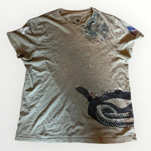 Ralph Lauren T-shirt - Säljer denna tvär feta och unika Ralph lauren T-shirt! Den är riktigt cool och är i storlek S! Tröjan har en cool orm på sig och ett coolt färg splatter mönster!