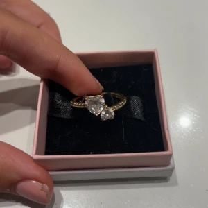 Guldring med hjärtformad sten från Pandora - Superfin guldfärgad ring från Pandora säljer för jag fick den av mitt ex så de är ej nå fel på den. Men man ser att den har andvänds lite 