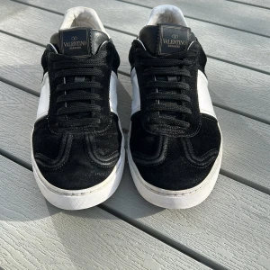 Valentino flycrew  - Snygga Valentino flycrew i svart och vitt med klassisk snörning. Skorna har en stilren design med en vit sula och svarta detaljer i mocka. Perfekta för en trendig look och till sommaren. Skicket är 7/10 saknas 5 stycken nitar🔥tveka inte att höra av er😊kan gå ner i pris vid snabb affär👍⭐️