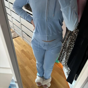 Ljusblå hoodie från Juicy Couture - Säljer en ljusblå hoodie från Juicy Couture med dragkedja och huva. Tröjan har långa ärmar och en liten logga på bröstet. Perfekt för en avslappnad stil. 💙 använd ett fåtal gånger! 