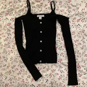 Svart ribbad off shoulder top med axelband🖤 Slits i ärmarna (se bild 3). Från H&M. Storlek XS men passar XS-M. Som nytt skick! 