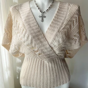 Beige tröja - ✨ Creme/beige stickad omlott-tröja ✨  💛 Genombruten stickad tröja med grovstickad look 🔹 Flattering V-ringning & omlott-design 🪽 Korta fladdermusärmar 💫 Tajt midja för feminin passform 📏 Storlek XS 📌 Noppror finns, men fortfarande fin & användbar