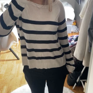 Randig tröja i bomull - Säljer en bekväm och stilren randig tröja i bomull. Tröjan har en klassisk design med vita och mörkblå ränder och långa ärmar. Tunt material och kan vara lite genomskinlig. 