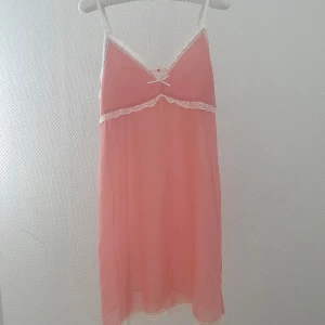 Nattlinne från Bella Bloom - Säljer ett sött nattlinne i aprikos färg från Bella Bloom med spetsdetaljer och en liten rosett framtill. Ge en fairy-coquette vibe som passar till sommaren. Ha en liten fläck i nedre kant av klänningen men syns inte när du har den på dig.
