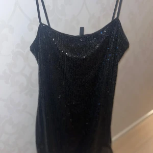 Svart glittrig klänning från H&M Divided - Snygg svart klänning från H&M Divided med glittrande detaljer. Köptes 2022 originalpriset var 300kr har jag för mig har används bara 4 gånger tror jag ❤️