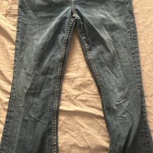 Blå jeansbyxor Gina tricot  - Snygga blå jeansbyxor med klassisk design. De har en bootcut-stil och normal passning, vilket ger en tidlös look. Perfekta för en avslappnad stil. Low waist, använd endast en gång. Nypris: 499