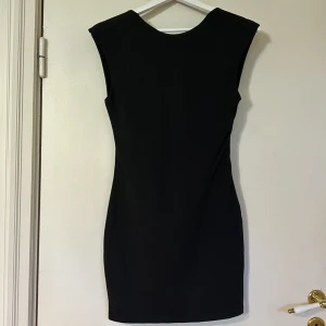 Svart klänning med öppen rygg - SHEIN  - Snygg svart ärmlös klänning med en elegant öppen rygg. Perfekt för en stilren look. Klänningen har en tight passform som framhäver figuren.Perfekt till sommarens alla festivaler 💃🥂🍾