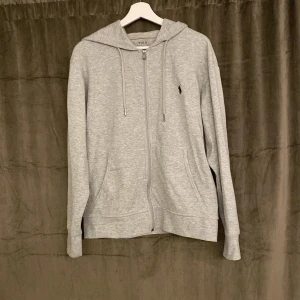 Grå Ralph lauren zip tröja - Bra skick 9/10, inte använd så mycket. Säljer då den är för stor för mig, nypris på tröjan är runt 1500kr  medans jag säljer den för 449. Inga defekter eller skador på tröjan.