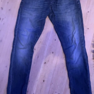 Blå jeans från Dondup - Snygga blå jeans från Dondup(George slim fit) med klassisk femficksdesign och knappgylf. Perfekta för en avslappnad stil med en modern touch. Tillverkade i Italien.