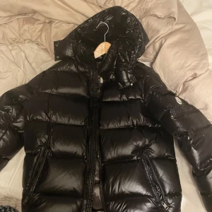 Svart dunjacka från Moncler - Säljer en snygg svart dunjacka från Moncler med glansig finish. Använd 3 gånger