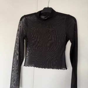 Genomskinlig topp - En svart genomskinlig topp, perfekt för festival eller liknande, storlek Medium!🫶från Gina tricot