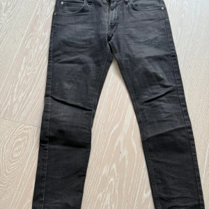 Svarta jeans från Lee Luke 30/32 - Snygga svarta jeans från Lee Luke med en klassisk design. De har en normal passform och är tillverkade i ett slitstarkt material. Perfekta för en stilren look.