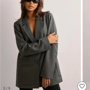 Grå kavaj från Pieces - Snygg grå kavaj från Pieces i en klassisk design. Kavajen har en normal passform med långa ärmar och knäppning fram. Perfekt för en stilren look.