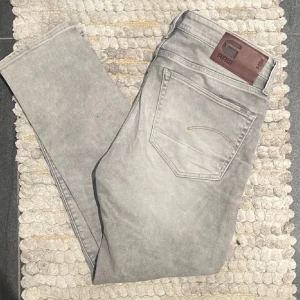 Grå jeans från G-Star RAW - Snygga grå jeans från G-Star RAW med en klassisk femficksdesign. De har en normal passform och är tillverkade i ett slitstarkt denimtyg. Perfekta för en avslappnad stil.