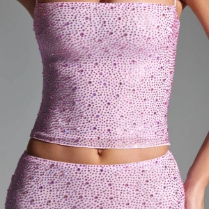 Rosa glittrig tubtopp - Snygg rosa tubtopp med glittrande paljetter över hela ytan. Perfekt för en festlig kväll. Toppen är croppad och har en åtsittande passform. Oanvänd 