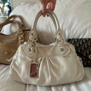 Vit Q Classic Baby Groove väska!  - Köp via min vinted @juliavallberg för bättre pris, plick tar ut dubbla avgifter 🤍 Snyggaste vita handväskan i äkta läder från Marc by Marc Jacobs. Den ikoniska modellen Q Classic Baby Groove! En populär och eftertraktad vintagemodell med silverdetaljer och dubbla handtag. Väskan är i fint skick med lite slitage på fötterna undertill men inget som syns tydligt. Slitage finns enligt bilder men helhetsintrycket är bra. Perfekt för dig som vill ha en stilren tidlös väska med riktigt bra kvalité!🤍