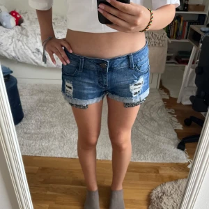 Blå jeansshorts med paljettdetaljer - Snygga blå jeansshorts från Valley Wear. Knappast använda, super coola glitter detaljer på fickorna, low Rise, och de piffar upp vilken outfit som helst💕