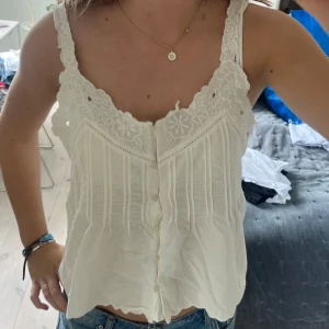 Vit spetsdetaljerad linnetopp - Supersöt vit linnetopp med broderade spetsdetaljer och blommönster!! 